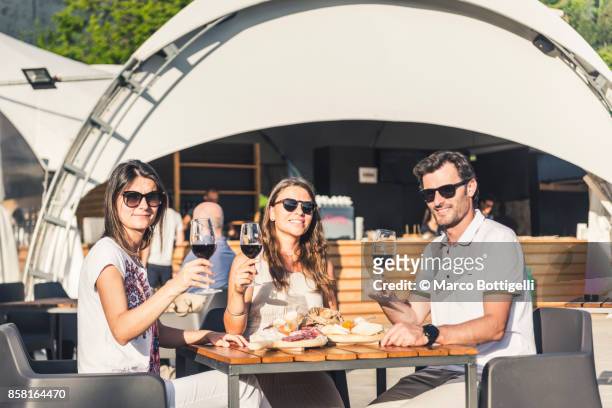 friends eating out in an outdoor restaurant, italy. - best taste 2017 stock pictures, royalty-free photos & images