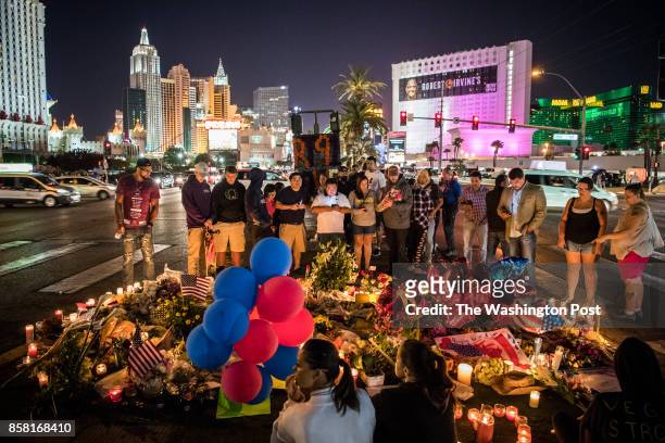 People pay tribute for Sunday's night mass shooting victims at vigil along Las Vegas Boulevard near Mandalay Bay hotel on Wednesday, October 4 in Las...
