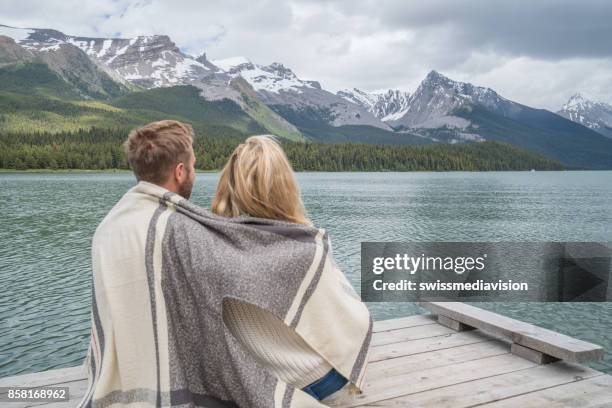 giovane coppia rilassante sul molo del lago - lago maligne foto e immagini stock