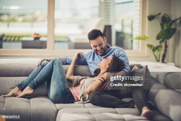 happy couple in love resting on the sofa at home and communicating. - penthouse stock pictures, royalty-free photos & images