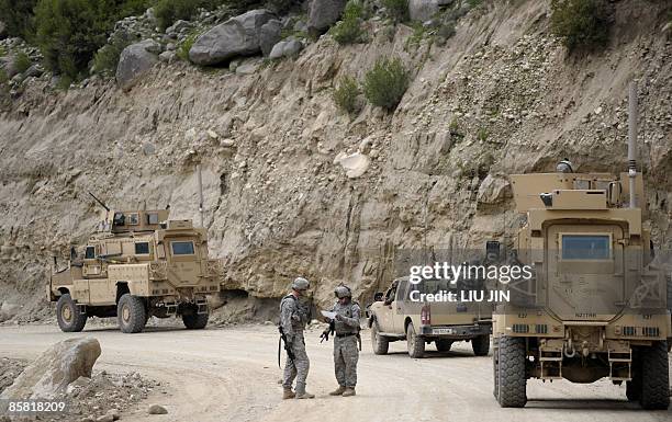 Soldiers from Charlie troop of 6-4 Cavalry talk beside their armoured vehicles along a road during a patrol in Nishagam, in Afghanistan's eastern...