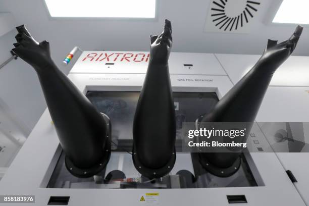 Rubber gloves extend, filled with pressurized air, from a reactor machine used in the production of semiconductor wafer products at the IQE Plc...