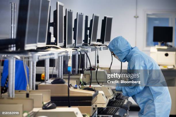 An employee tests a semiconductor wafer products in the 'clean room' laboratory at the IQE Plc headquarters in Cardiff, U.K., on Thursday, Sept. 28,...