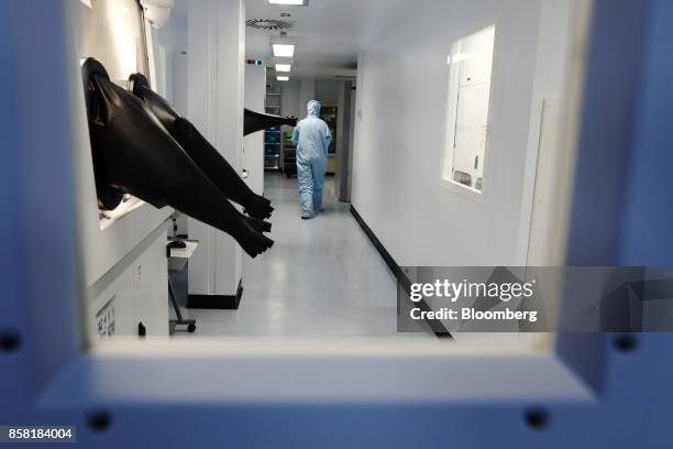 An employee works in a 'clean room' laboratory loading semiconductor wafer products at the IQE Plc headquarters in Cardiff, U.K., on Thursday, Sept....