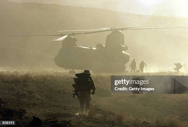 United States and Canadian Army medics render first aid to an American soldier, who fainted due to altitude sickness, during search and destroy...