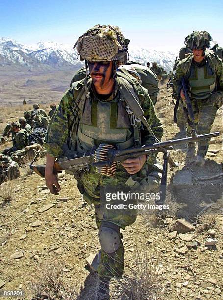 Soldiers from Princess Patricia's Canadian Light Infantry battalion go to their positions March 15, 2002 during a combat mission in the rugged...