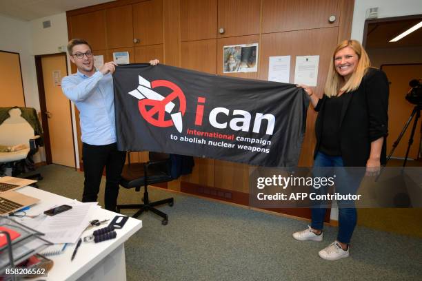 Nuclear disarmament group ICAN executive director Beatrice Fihn and coordinator Daniel Hogsta hold a banner with their logo after ICAN won the Nobel...