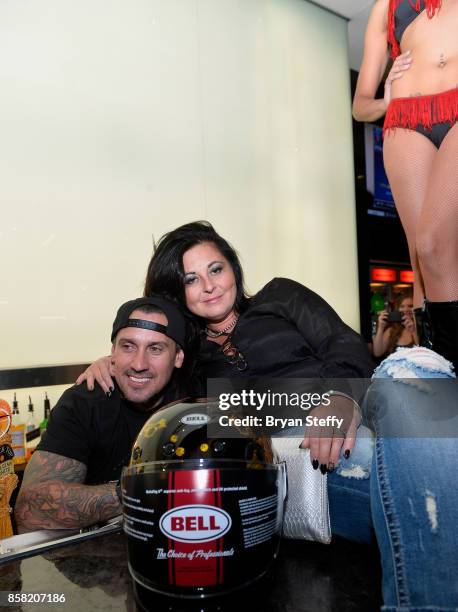 Freestyle motocross rider Carey Hart presents a guest with a custom painted helmet as he surprises guests as a bartender in support of Carey Hart's...