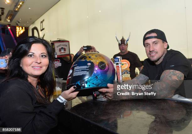 Freestyle motocross rider Carey Hart presents a guest with a custom painted helmet as he surprises guests as a bartender in support of Carey Hart's...