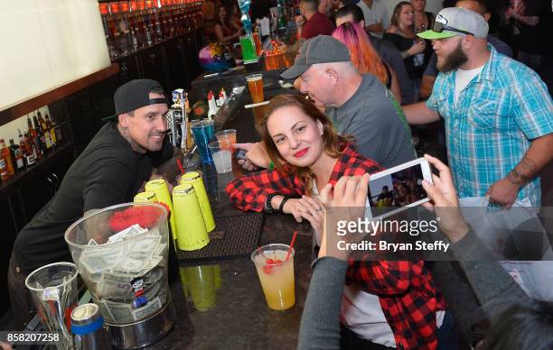 Freestyle motocross rider Carey Hart takes a photo with a fan as he surprises guests as a bartender in support of Carey Hart's Good Ride Rally...
