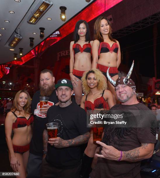 Rapper Bryan 'Big B' Mahoney, freestyle motocross rider Carey Hart and television personality 'Horny' Mike Henry pose with bar staff as they surprise...