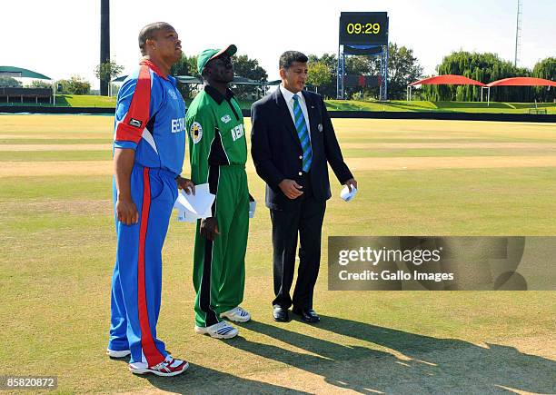 Match referee Roshan Mahanama of Sri Lanka tosses the coin with Bermuda captain Irving Romaine and Kenya captain Steve Tikolo before the start of the...