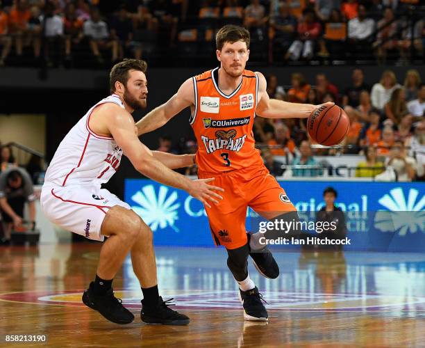 Cam Gliddon of the Taipans looks to get past Mitch Norton of the Hawks during the round one NBL match between the Cairns Taipans and the Illawarra...