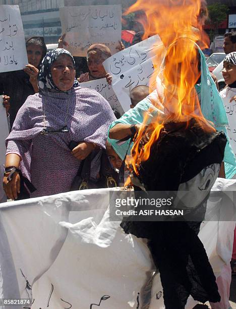 Activists of civil society torch an effigy of a Taliban during a protest in Karachi on April 6 against the public flogging of a veiled woman....