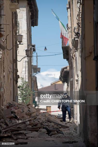 Woman walks in the rubble in a street of the old city of Abruzzo capital L'Aquila, epicentre of an earthquake on April 6, 2009. A violent earthquake...