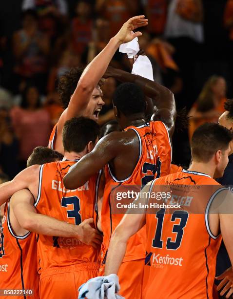 Alex Loughton of the Taipans celebrates with teammates after scoring the winning basket during the round one NBL match between the Cairns Taipans and...