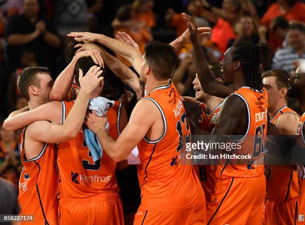 Alex Loughton of the Taipans celebrates with teammates after scoring the winning basket during the round one NBL match between the Cairns Taipans and...