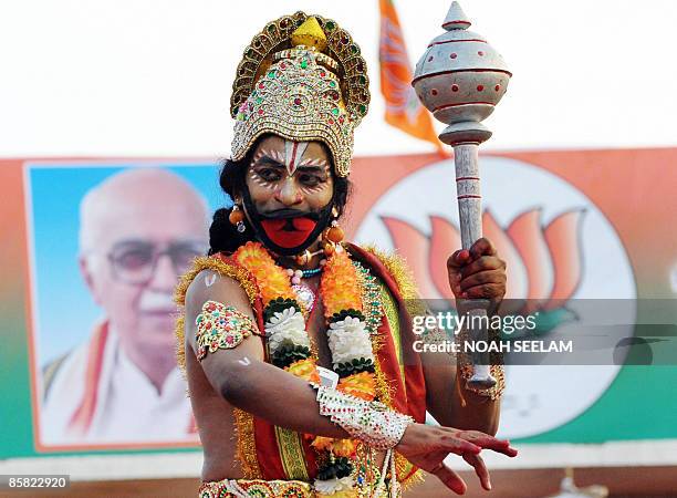 An Indian artist dressed like the Hindu God Lord Hanuman entertains the crowd during the Bharatiya Janatha Party election campaign public meeting in...