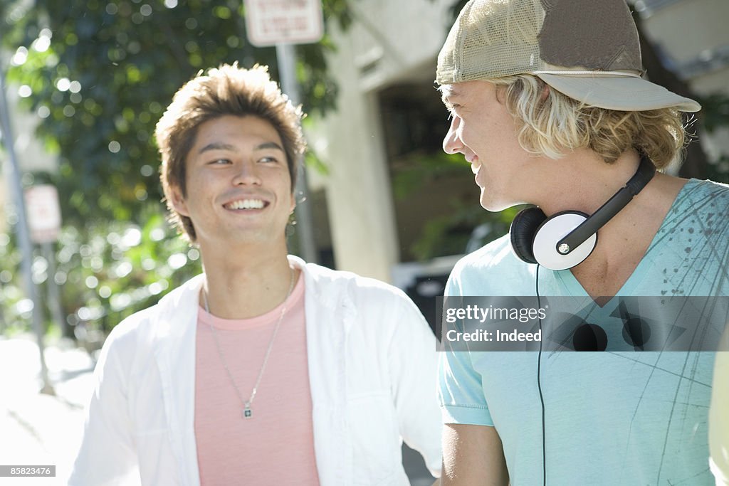 Two young men smiling face to face