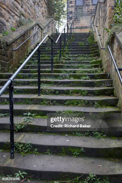 Worn stone steps rise uphill in a Northumbrian town side street, on 26th September 2017, in Alnwick, Northumberland, England.