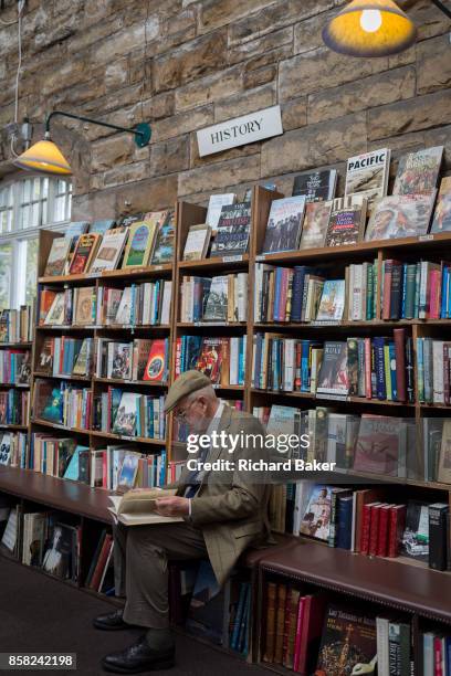 Surrounded by used books is an elderly gentleman reading a title the the shelves of the second-hand bookshop 'Barter Books' in the Northumbrian town...