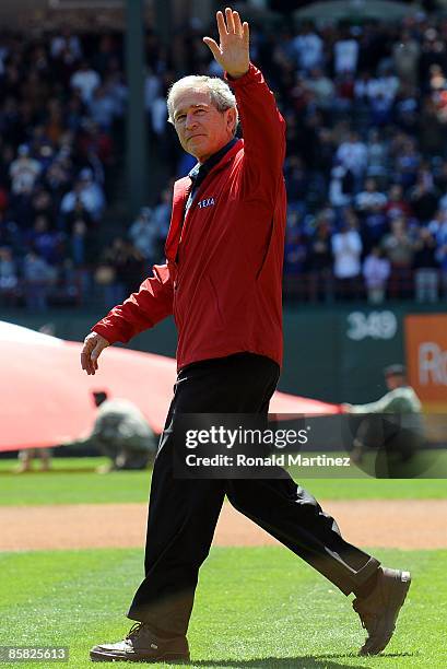 Former President George W. Bush waves to the crowd before throwing out the ceremonial first pitch during the home opener of the Texas Rangers at...