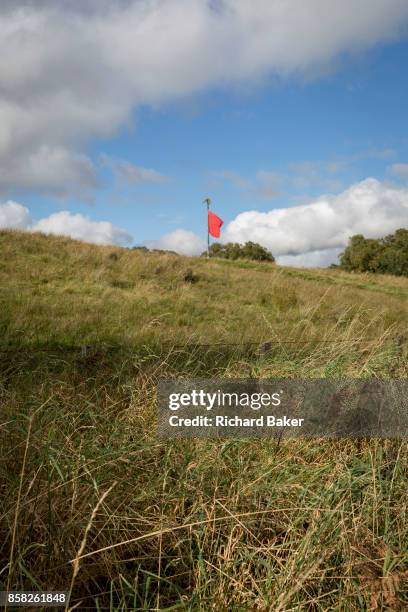 Red warning flag flies on the perimeter during military live firing at Otterburn Ranges, on 28th September 2017, in Otterburn, Northumberland,...