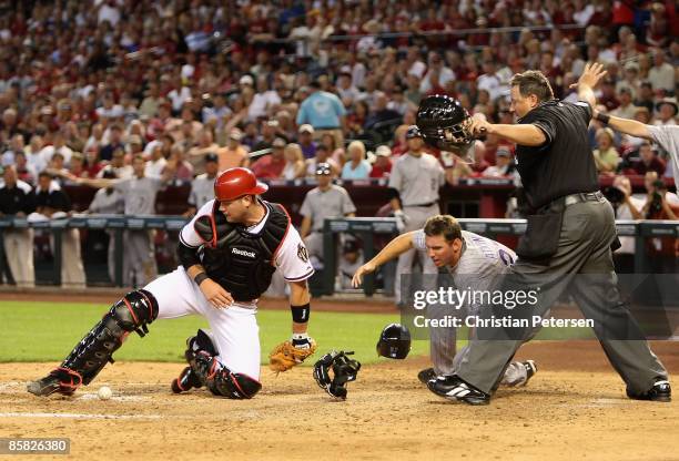 Chris Snyder of the Arizona Diamondbacks can't hold onto the ball at home plate as Garrett Atkins of the Colorado Rockies slides in safely during the...