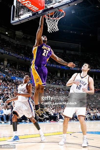 Josh Powell of the Los Angeles Lakers goes to the basket over Russell Westbrook and Nenad Krstic of the Oklahoma City Thunder during the game on...