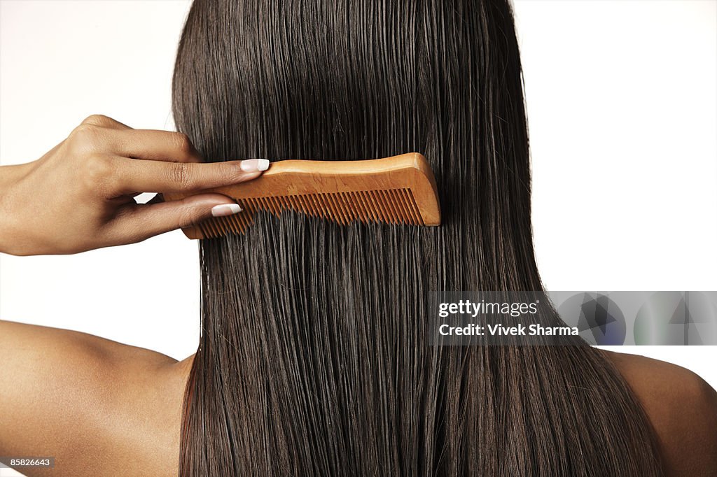 Woman pulling comb through her hair
