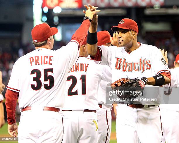 Infielder Tony Clark of the Arizona Diamondbacks celebrates with pitching coach Bryan Price after defeating the Colorado Rockies in the MLB openning...