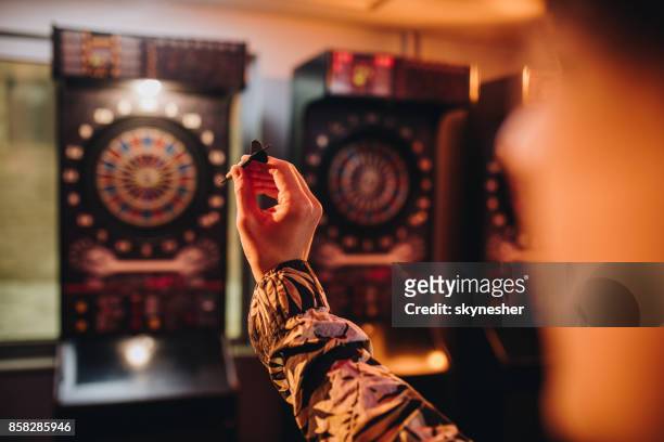 unrecognizable person aiming at dartboard in a pub. - pub darts stock pictures, royalty-free photos & images