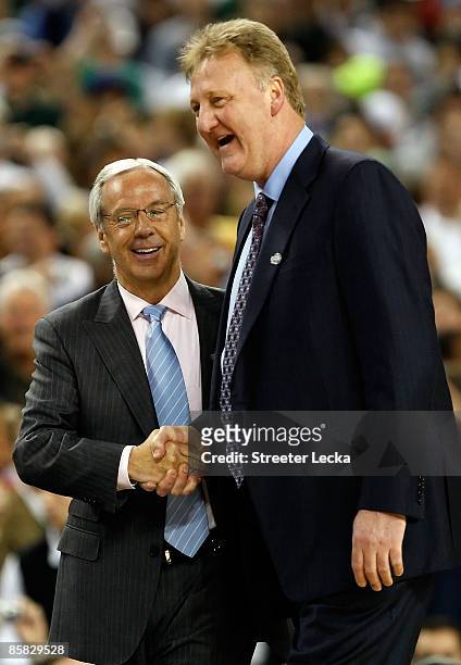 Head coach Roy Williams of the North Carolina Tar Heels shakes hands with Larry Bird, who presented the game ball along with Earvin "Magic" Johnson...