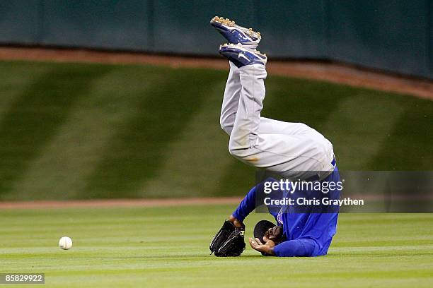 Milton Bradley of the Chicago Cubs flips over after missing a fly ball against the Houston Astros on Opening Day on April 6, 2009 at Minute Maid Park...