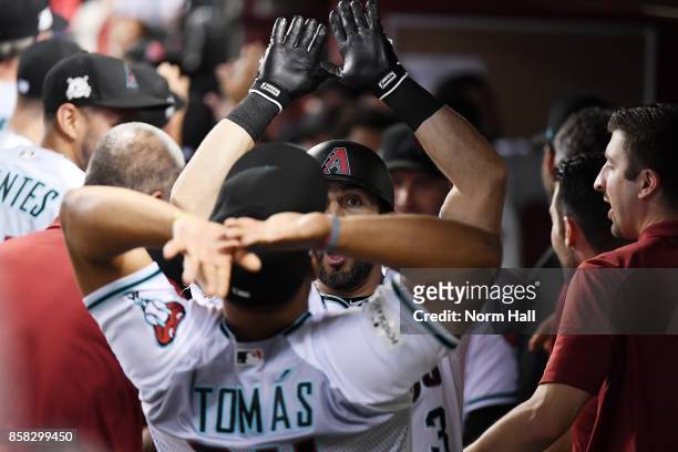 Daniel Descalso of the Arizona Diamondbacks celebrates with teammate Yasmany Tomas after hitting a two run home run during the bottom of the third...