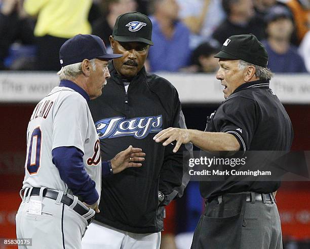 Jim Leyland of the Detroit Tigers and Cito Gaston of the Toronto Blue Jays talk to home plate umpire Ed Montague during the eighth inning when play...