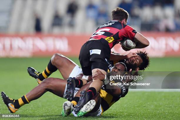 George Bridge of Canterbury is tackled by Manasa Mataele of Taranaki and Seta Tamanivalu of Taranaki during the round eight Mitre 10 Cup match...