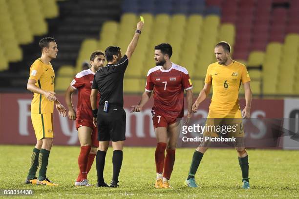 October 5: Referee Alireza Faghani of the Islamic Republic of Iran shows Omar Khrbin of Syra the yellow card during the FIFA 2018 World Cup Asian...