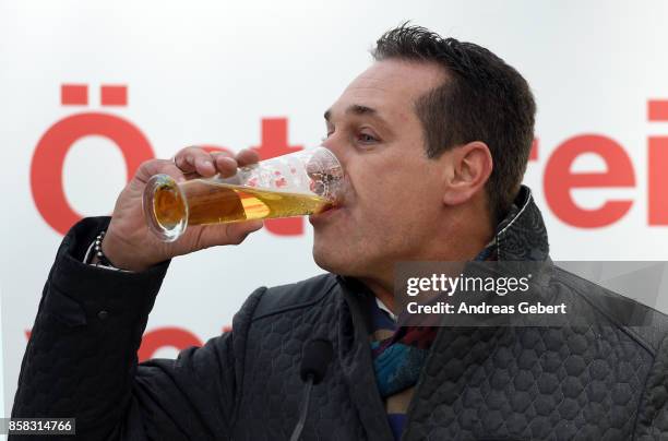 Heinz-Christian Strache of the right-wing Austria Freedom Party drinks beer after speaking to supporters at an election campaign rally on October 6,...