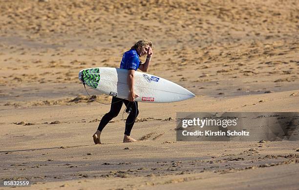 Local surfer and wildcard entrant Adam Robertson of Australia signals his relief to friend and family members on the beach after winning an...