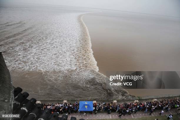 Visitors crowd to watch the soaring tide of the Qiantang River at Yanguan Ancient Town on October 6, 2017 in Jiaxing, Zhejiang Province of China....