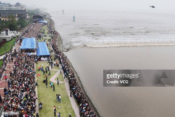 Visitors crowd to watch the soaring tide of the Qiantang River at Yanguan Ancient Town on October 6, 2017 in Jiaxing, Zhejiang Province of China....