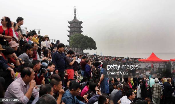 Visitors crowd to watch the soaring tide of the Qiantang River on October 6, 2017 in Hangzhou, Zhejiang Province of China. When the surging tide...