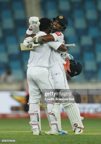 Dimuth Karunaratne of Sri Lanka is congratulated by Dinesh Chandimal of Sri Lanka after reaching his century during Day One of the Second Test...