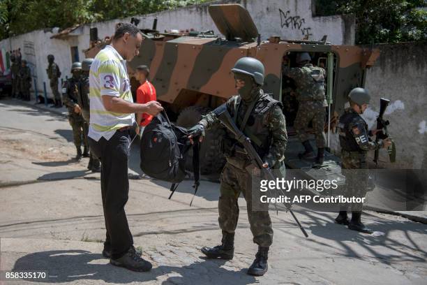 Resident of Morro dos Macacos favela is searched by a Brazilian Armed Forces soldier during a security operation in the area in Rio de Janeiro,...