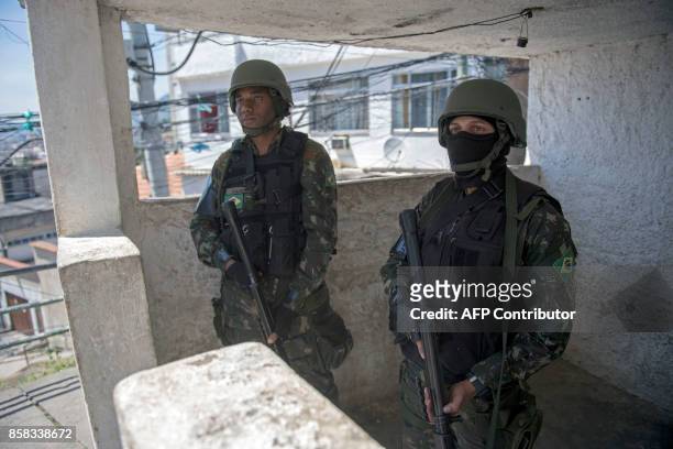 Brazilian Armed Forces soldiers keep watch on the Morro dos Macacos favela during a security operation in the area in Rio de Janeiro, Brazil on...