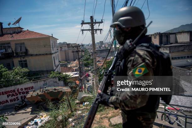 Brazilian Armed Forces soldier keeps watch on the Morro dos Macacos favela during a security operation in the area in Rio de Janeiro, Brazil on...