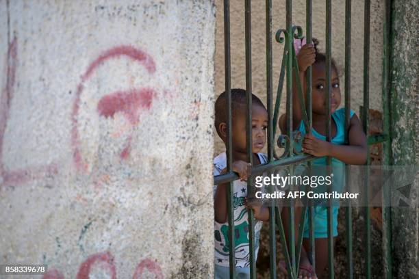 Local children stand behind a fence during a security operation at the Morro dos Macacos favela in Rio de Janeiro, Brazil on October 6, 2017....