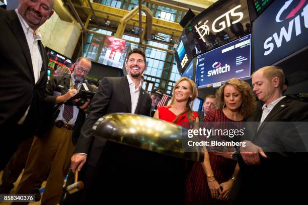 Rob Roy, founder and chief executive officer of Switch Inc., center left, smiles during the company's initial public offering on the floor of the New...