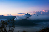 Smoke coming out of mount Bromo surrounded by mist.